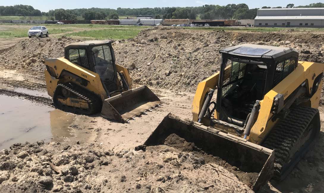 Skid loaders at a construction site.